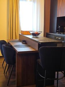 une cuisine avec un comptoir et des chaises autour de la cuisine dans l'établissement Lavish Apartment, à Dej