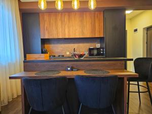 une cuisine avec un bar avec des tabourets de bar bleus dans l'établissement Lavish Apartment, à Dej 24 autres photos