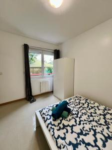 a bedroom with a bed with a blue pillow on it at Gagny charmant deux pièces très calme in Gagny