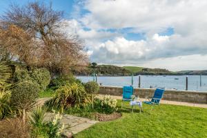 two chairs sitting on the grass near the water at Flat 1 The Salcombe in Salcombe