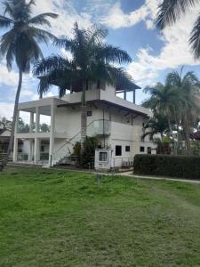 a building with palm trees in front of it at Vacacional Laas Pascualas in Sánchez
