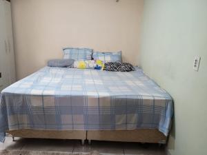 a bed in a room with a blue and white blanket at COP30 Casa Completa - Prox Belém in Barcarena