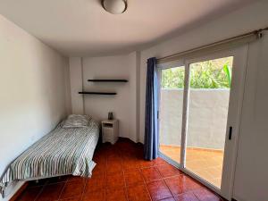 a bedroom with a bed and a sliding glass door at Apartamento El Platanal in Tazacorte +8 photos