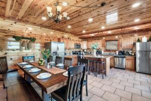 a kitchen with a wooden ceiling and a table with chairs at Smoky Mountain Splash in Sevierville