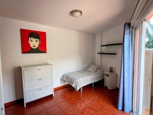 a bedroom with a bed and a painting on the wall at Apartamento El Platanal in Tazacorte