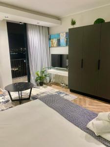 a bedroom with a large green cabinet and a bed at On Park Century City Cozy Apartment in Cape Town