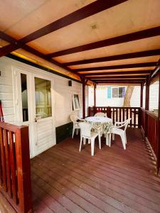 a patio with a table and chairs on a deck at Buona Mobile Homes on Camping Mare e Pineta in Lido di Spina