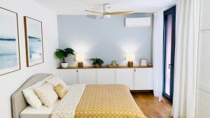 a white bedroom with a bed and a window at SEAESTA Cosy Sea Apartment in Koper