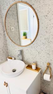 a bathroom with a white sink and a mirror at SEAESTA Cosy Sea Apartment in Koper