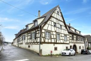 an old house with a car parked in front of it at L'Atypique au coeur du Vignoble in Hunawihr