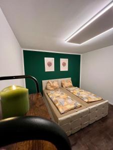 a room with two beds and a table and a green wall at Your Home Away #Worker Accommodation in Erkrath +8 photos