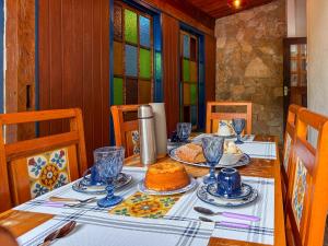 a dining room table with a cake on it at Jardim da Música Tiradentes in Tiradentes