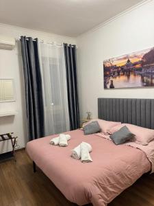 1 dormitorio con 1 cama rosa y 2 almohadas en ROMA FATATA near metro Jonio, en Roma