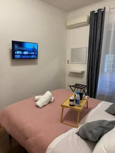 Un dormitorio con una cama con un televisor en la pared. en ROMA FATATA near metro Jonio, en Roma 23 fotos más