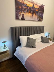 Una cama en un dormitorio con un cuadro en la pared. en ROMA FATATA near metro Jonio, en Roma