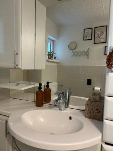 a bathroom with a white sink and a mirror at FeWo am Mainplatz in Teltow +39 photos