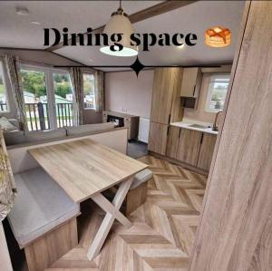 a dining space with a wooden table in a caravan at Escape in Carnforth Lodge - Sleeps 6 in Carnforth +20 photos