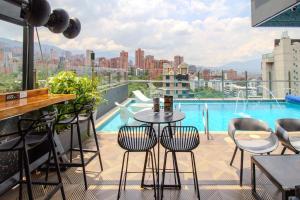a balcony with a table and chairs and a pool at Haven A Design Hotel in Medellín