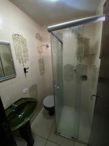 a bathroom with a shower and a sink and a toilet at Suite linda completa in Curitiba