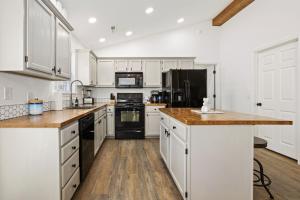 a kitchen with white cabinets and black appliances at Rockrider House-MTB Trail-Pet Friendly in Bella Vista