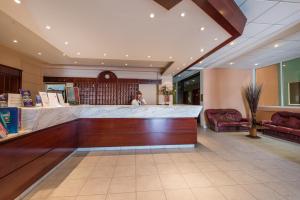 a woman standing behind a counter in a lobby at Astir Palace Hotel in Laganas