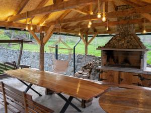 a wooden table in a pavilion with a fireplace at OraHouse in Orahovica