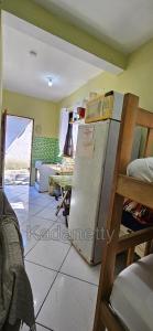 een kamer met een koelkast en een tafel in een kamer bij Casa Ventilada e Confortável, Perto da Rodovia e 2km da Praia in Caraguatatuba