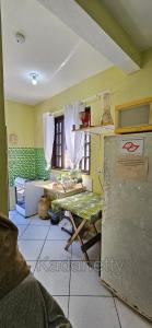een keuken met een tafel in een kamer bij Casa Ventilada e Confortável, Perto da Rodovia e 2km da Praia in Caraguatatuba