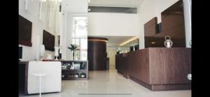 a living room with a white and brown kitchen at Diamond Flat Aparthotel REDE Mont Blanc in Nova Iguaçu
