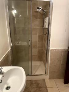 a shower with a glass door next to a sink at Hannah in Cashel +17 photos