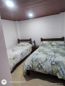 two beds sitting next to each other in a bedroom at Apartamento el Rubí 202 in Cómbita