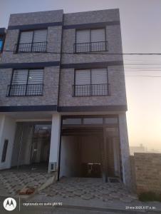 a large brick building with a garage at Apartamento el Rubí 202 in Cómbita