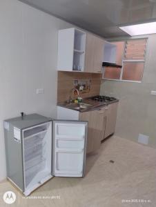 a kitchen with a white refrigerator and a sink at Apartamento el Rubí 202 in Cómbita