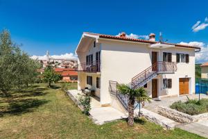 une grande maison blanche avec une cour dans l'établissement House Lilly, à Višnjan