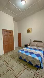 Un dormitorio con una cama con una manta azul y blanca. en Hostal VELVET PLAZA, en Santa Ana 14 fotos más