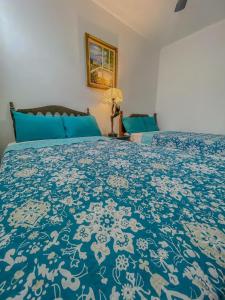 Un dormitorio con una cama con una colcha azul y blanca. en Hostal VELVET PLAZA, en Santa Ana