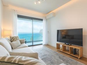 sala de estar con TV grande y ventana grande en Glamorous Apartment by Atlantic Holiday, en Funchal