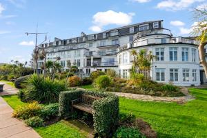 a large white building with a bench in a garden at N ° 42 The Salcombe in Salcombe