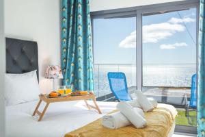 a room with a bed and a table and a large window at Aqui ha Casa by AH in Gaula
