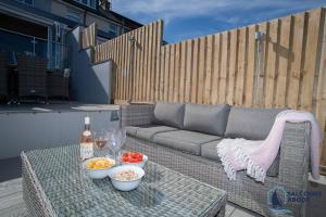 a table with bowls of food and a bottle of wine at Stylish Sanctuary - Estuary Views - Outside Space in Salcombe