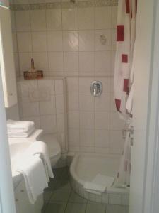 ein Badezimmer mit einer Badewanne, einem WC und einem Waschbecken in der Unterkunft Appartement Haus Hamburg in Bad Füssing