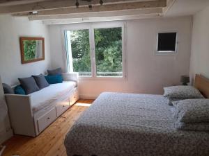 a living room with a couch and a window at 4 étoiles spacieux Gîte centre-ville, terrasse ensoleillée, parking et Wi-Fi in Magnac-Laval