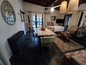 a living room with a table and a bed at Casa de 2 ambientes - Barrio Residencial in Balcarce