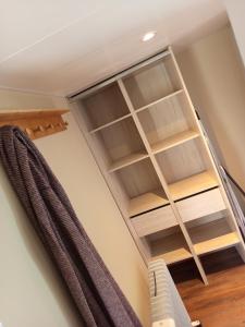 a book shelf in a room with a ceiling at Mobil-home rénové tout confort, terrasse couverte, climatisation, arrivée autonome in Fourmies