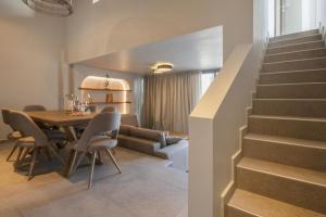 a dining room with a table and chairs and a staircase at Anemelia Villas in Karpathos Town