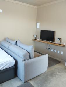 Una sala de estar con un sofá y un televisor. en Caraguá House, en Caraguatatuba
