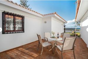 a dining room with a table and chairs on a patio at Villa del Mar Palm Mar in Palm-mar