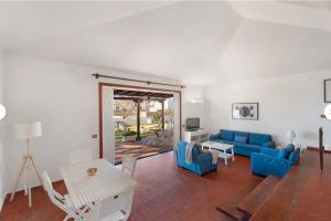 a living room with a blue couch and a table at Villa del Mar Palm Mar in Palm-mar