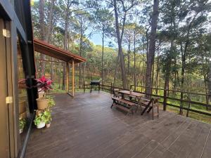 a deck with a picnic table and a grill at Cabañita Alpina para Parejas in Mazamitla