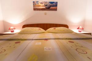 a bedroom with a bed with two lamps on tables at Apartments Pende in Rab